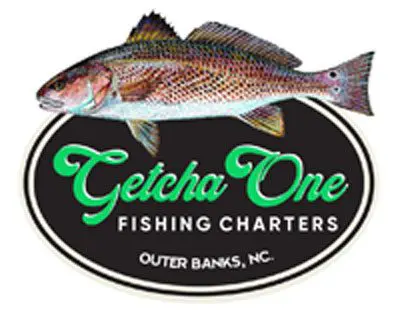 Logo of getcha one fishing charters featuring an illustrated fish above the text, set against a black oval background with location outer banks, nc.